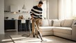 © Svyatoslav Lypynskyy - Man Vacuuming Living Room Carpet Bright Sunlight