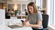 © Vyatcheslav - Young woman using smartphone at office desk. Professional female employee working in modern open plan workplace. Casual business person with laptop and mobile phone