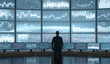 © andyaziz6 - Business professional standing in front of multiple large digital screens displaying financial graphs and stock market data in a high-tech control room