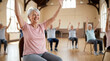© ViskBx - Group of active seniors participating in a chair exercise class in a community center, focusing on health and fitness in old age