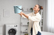 © Pixel-Shot - Worried young woman placing bucket under water dripping from ceiling in bathroom