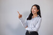 © crizzystudio - Young asian woman smiling pointing up showing direction
