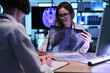 © H_Ko - Two medical experts engage in a discussion over X-ray images at a busy clinic. One doctor smiles while explaining findings, showcasing teamwork and dedication to patient health.