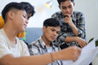 © Gatot - Four Young Asian Male Student Looking at Documents Together During Collaborative Group Study Session