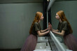 © Westend61 - Red haired freckled woman with tulle skirt gazing at reflection in mirror