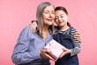 © New Africa - Little girl greeting her grandmother with gift on pink background