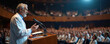 © miss irine - Elderly man in white coat gives speech at medical conference. He stands at podium addressing crowd in auditorium. Healthcare professionals listen attentively.