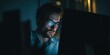 © mryanfahrudin1 - Man focused on computer screen in dark setting with illuminated glasses