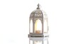 © Cetak - Ornate white lantern with lit candle. Delicate cutout designs. Bright background