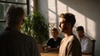 © Thares2020 - A team in a sunlit office experiences dramatic light and shadow interplay during a focused meeting or discussion