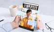 © Prostock-studio - A man in a shirt sits at a desk with a cup nearby. He is holding a tablet with a blank screen during an online meeting. Glasses are placed on the desk.