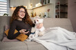 © Jelena - Woman relaxing at home with dog watching television