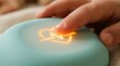 © Said Ali - A person's finger pressing a glowing orange button on a blue device