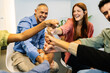 © Xavier Lorenzo - Diverse business team smiling and laughing, stacking hands in a circle, symbolizing unity, collaboration, and support in office. Teamwork and business concept