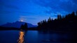 © robertharding - Moonlight reflects on Jack Lake with mountains and trees in the background near Banff, Alberta, Canada