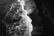 © Ari - Aerial, monochrome view of ocean waves crashing onto dark sand. Contrast between foam and shore