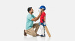© PRASANNAPIX - Indian Father Helps Son Prepare Cricket Helmet for Game