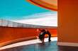 © VISTA by Westend61 - Teenager dancing energetically outdoors by terracotta architecture