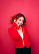 © VISTA by Westend61 - Redhead in red jacket smiling while talking on telephone outdoors
