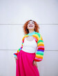 © VISTA by Westend61 - Red haired woman in colorful rainbow fashion smiling joyfully