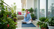 © PRASANNAPIX - Woman practicing pranayama on balcony surrounded by green plants