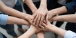 © Studicon - Many diverse hands stack together showing unity and teamwork to achieve common goals