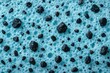 © Ingeniously - Macro view of porous foam with embedded dark mineral particles showing composite material structure and texture