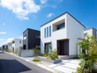 © Jumpei - 青空の下にモダンなデザインの戸建て住宅が立ち並ぶ新築住宅街の美しい街並み景観写真