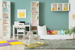 © Pixel-Shot - Comfortable bed, table and shelving units in interior of children's room