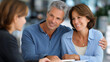 © Nataliya - Professional consultant discussing options with a couple at an office desk, financial advice, retirement strategy, professional planning services, wealth consultation, defocused