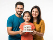 © Someone Cooked Here - indian family holding house model child centered happy home ownership concept casual lifestyle