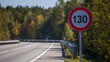 © A2Z AI  - Speed limit sign 130 km/h next to a highway or motorway with a guardrail and lush autumn trees under a clear sky, travel concept