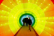 © Julien McRoberts - People Walking Through Colorful Light Tunnel Symbolizing Journey and Transition