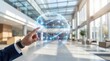 © fatima - Businessman interacting with futuristic digital globe in modern office lobby with glass ceiling and blurred background