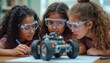 © Lubov - Three young girls wearing safety goggles work together on a robot car in a classroom setting. They are focused on the project, learning and collaborating. Science education promotes STEM skills.