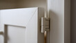 © photo for everything - Close-up view of a clean minimalist white cabinet door and modern functional hinge, highlighting contemporary design and subtle texture details