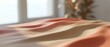 © Yuliia - Soft flowing fabric in warm coral and peach tones with gentle shadows and natural window light creating elegant textile waves for interior design projects.