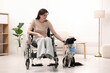 © New Africa - Woman in wheelchair and her service dog indoors