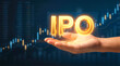 © pufanya - Hand presenting glowing golden IPO letters. Upward financial candlestick charts on dark blue background. Initial public offering and investment opportunity concept