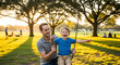 © StockHive - a man and a young boy playing in a park with trees in the background outdoor activity family fun par