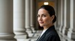 © unlimited - Professional woman wearing formal attire stands confidently in a classical architectural setting