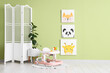 © Pixel-Shot - Interior of children's room with baby walker, folding screen and pictures