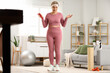 © Pixel-Shot - Sporty mature woman with menopause measuring weight at home