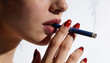 © Ryzhkov - Close up of a woman holding a blue cigarette to her lips for an anti-smoking editorial campaign on a white background with ample copy space for text