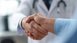 © Curioso.Photography - Close-up of a handshake between a doctor and a patient, symbolizing trust, agreement, and healthcare partnership.