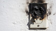 © sonderstock - Burned electrical outlet fire damage charred wall hazard faulty wiring short circuit safety risk