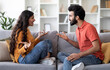 © Prostock-studio - Domestic Conflicts. Portrait Of Young Indian Couple Arguing At Home, Millennial Eastern Spouses Suffering Relationship Problems And Misunderstanding, Sitting On Couch And Quarreling With Each Other