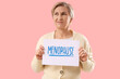 © Pixel-Shot - Thoughtful mature woman holding paper with word MENOPAUSE on pink background