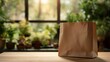 © sornram - A stylish paper shopping bag on a wooden table, surrounded by lush plants, ideal for eco-friendly shopping.