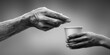 © NovaVision - Hands exchanging a coin and a cup in black and white